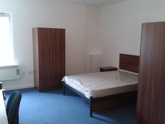 Studio room with a double bed, wardrobes and a desk